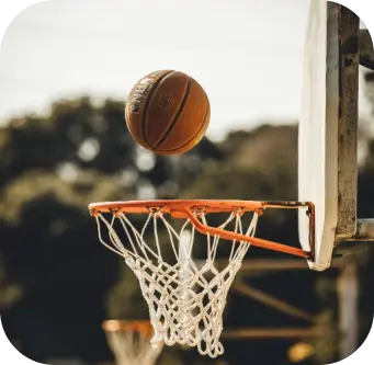 Player scoring a basketball shot into the hoop at sports academy event